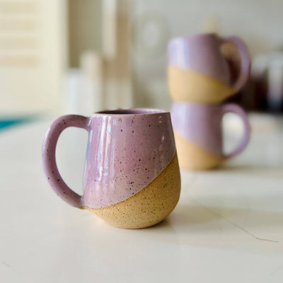 Two ceramic mugs with a gradient design on a light surface.