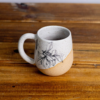Ceramic mug with a floral design on a wooden surface