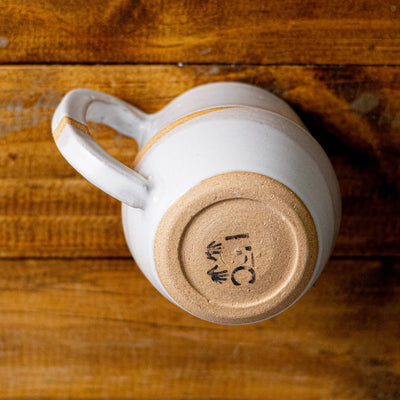 White mug with a wooden base on a wooden surface