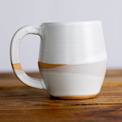 White ceramic mug with brown accents on a wooden surface