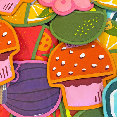 Colorful fruit-shaped placemats with visible brand labels.