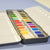 Set of watercolor paints in a case on a light blue background