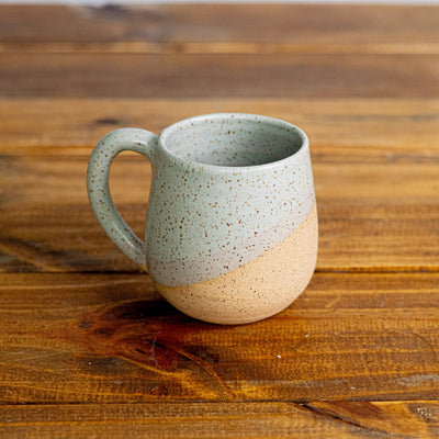 Speckled ceramic mug on a wooden surface