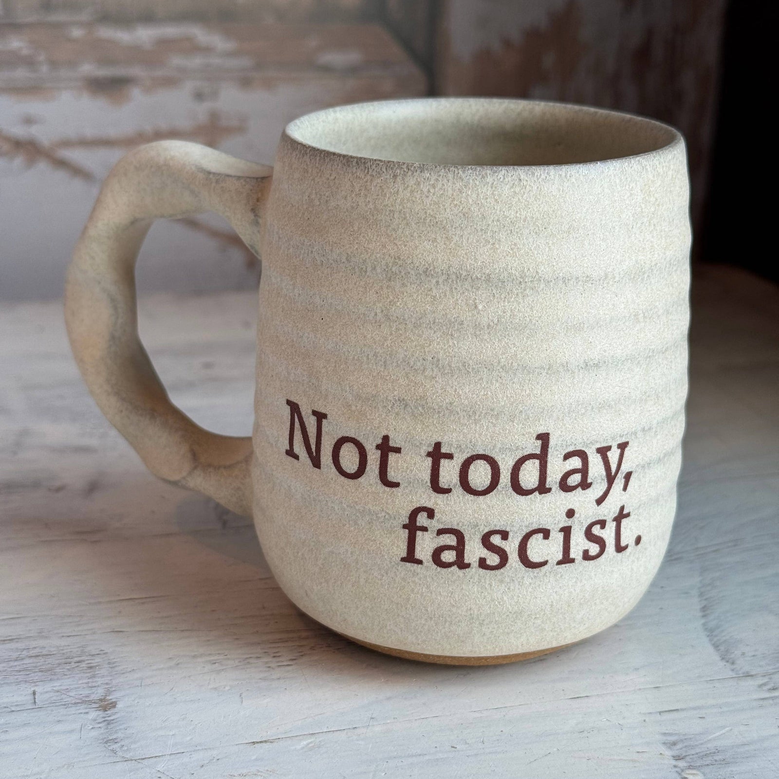 Beige ceramic mug with 'Not today, fascist.'