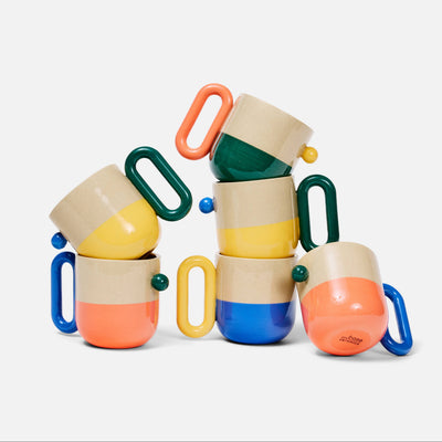 A set of colorful mugs with handles, stacked in a playful pile on a white background.
