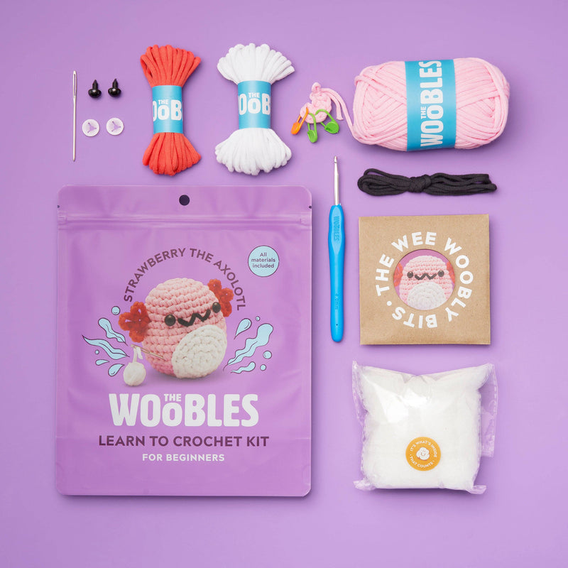 Crocheted pink Axolotl toy on a purple background