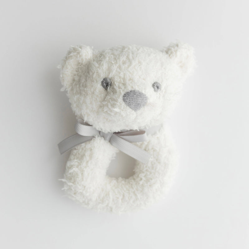 Pink teddy bear rattle with a gray bow on a white background