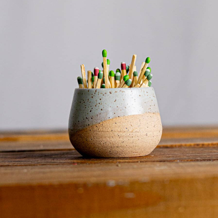Ceramic match striker with matches on a wooden surface