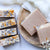 Handmade soap bars with natural designs on a wooden plate and white background