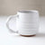 White ceramic mug on a light surface with a neutral background