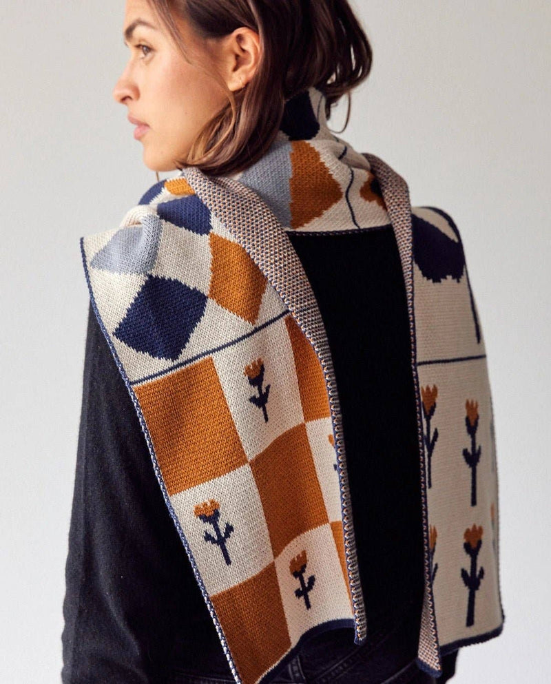Knitted scarf with floral and diamond pattern on a white background