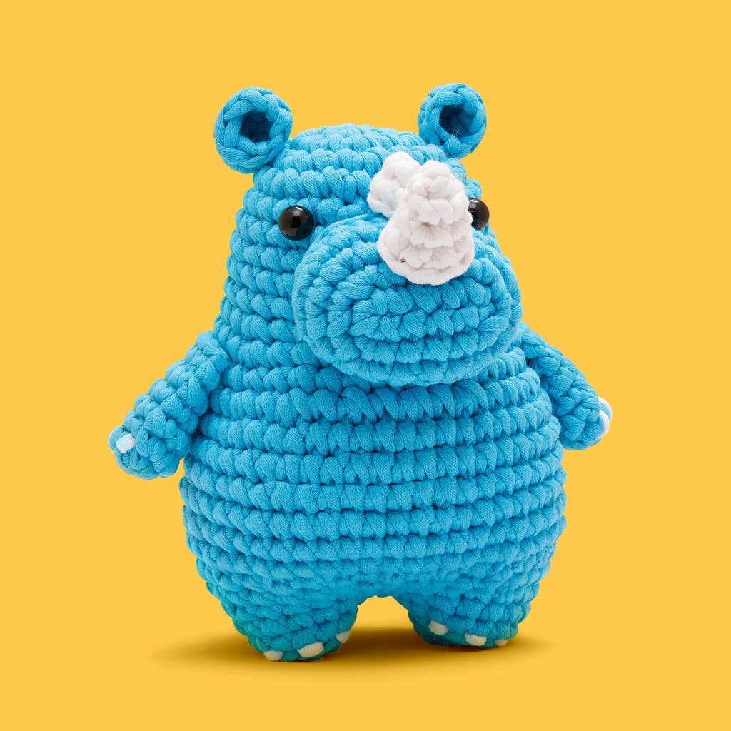 Blue plush rhino toy on a yellow background