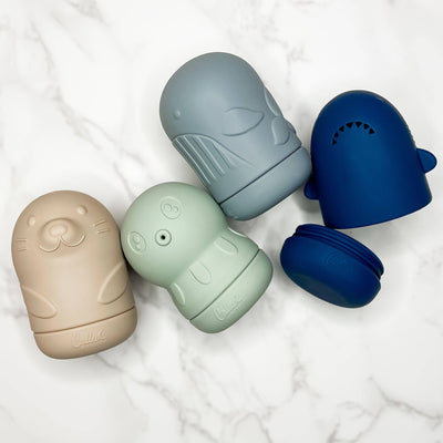 Set of four colorful bath toys on a light background.