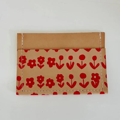 Tan leather wallet with red flowers on a white background.
