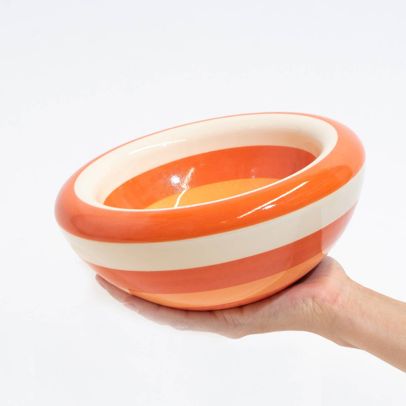 A set of ceramic bowls with concentric orange and cream spiral patterns, arranged on a white background.