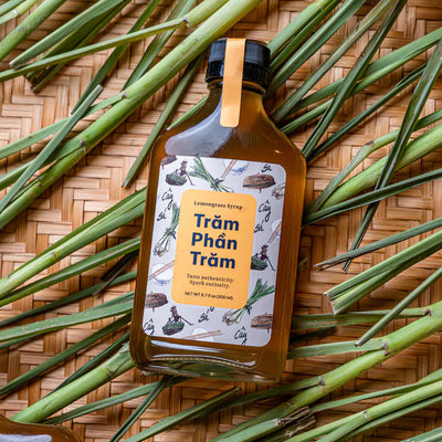 Bottle of Tram Phan Tram on a woven mat with green leaves