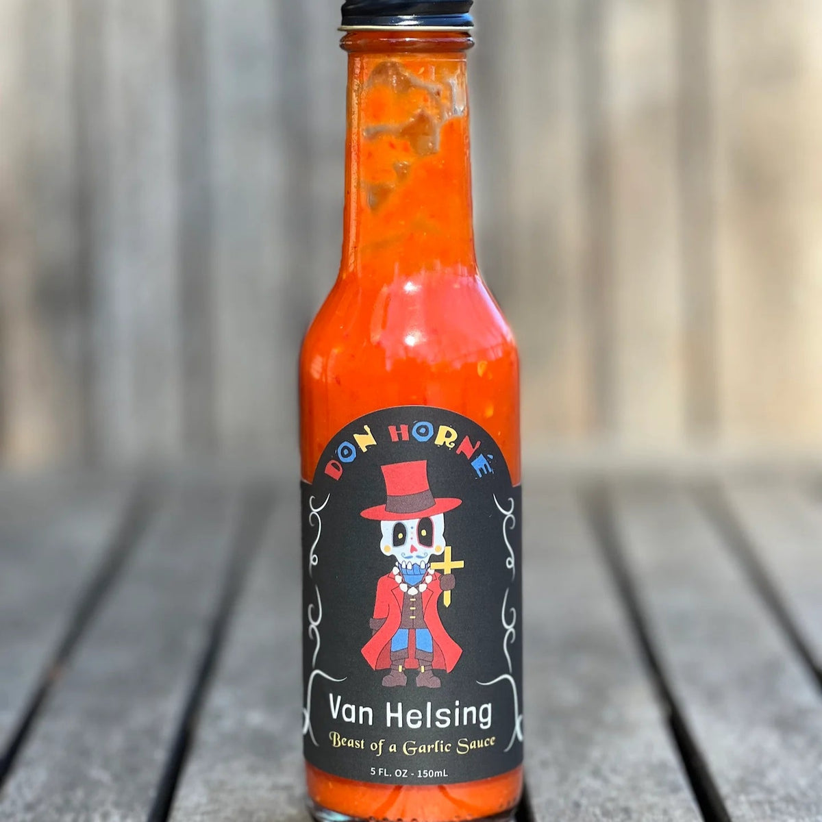 Hot sauce bottle with a label featuring a character on a wooden surface