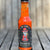 Hot sauce bottle with a label featuring a character on a wooden surface