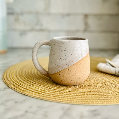 Two-tone ceramic mug on a woven placemat