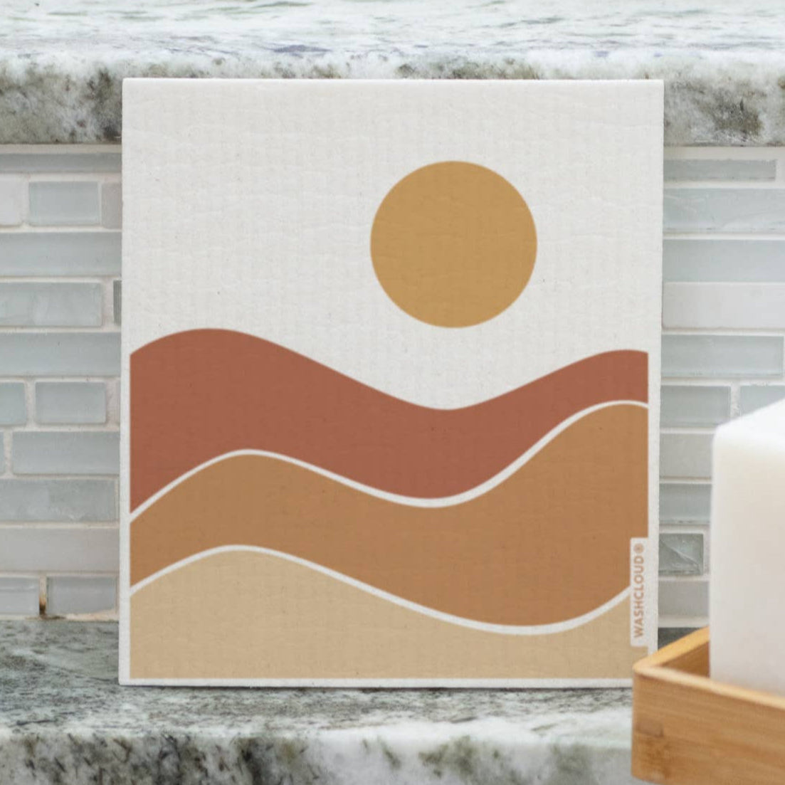 Abstract wall art with wavy lines and a sun on a marble countertop.