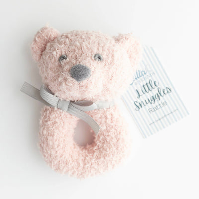 Pink teddy bear rattle with a gray bow on a white background