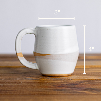 White ceramic mug with brown accents on a wooden surface, measurements indicated.