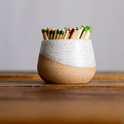 Ceramic match striker with matches on a wooden surface