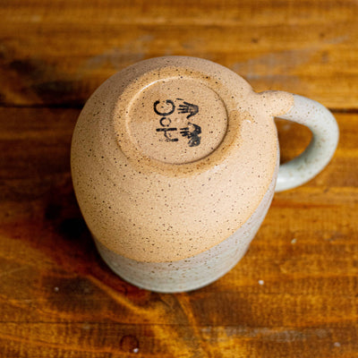 Ceramic mug with a logo on a wooden surface