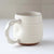 White ceramic mug on a light surface with a neutral background