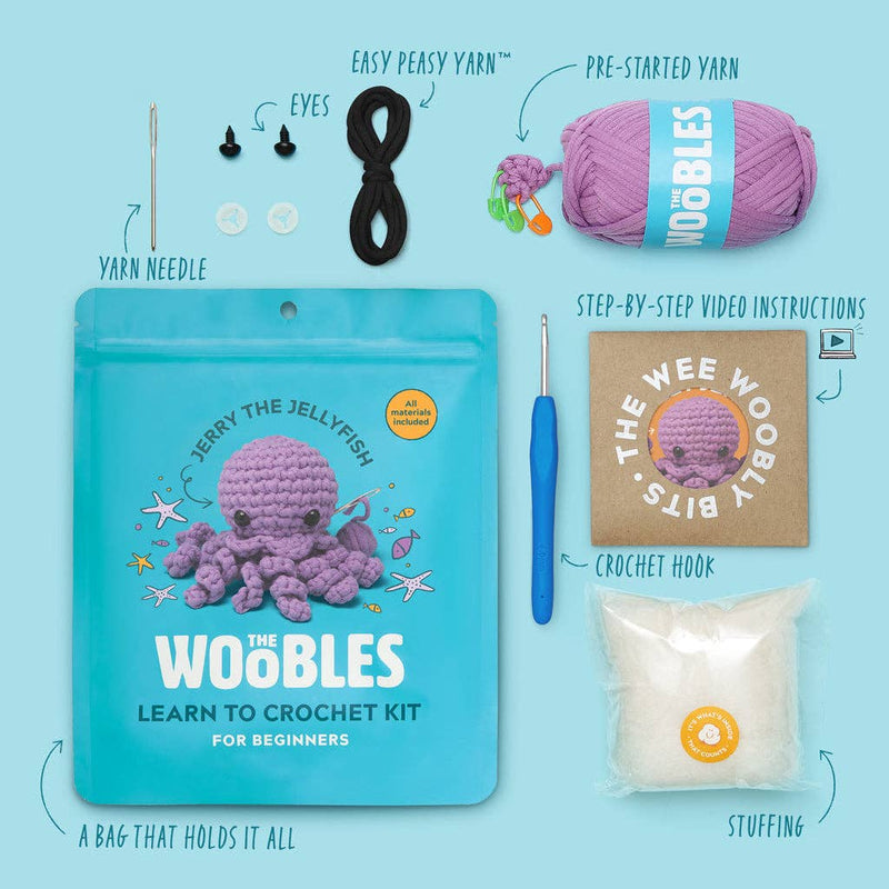 A purple crocheted octopus toy with black bead eyes and a silver crochet hook attached to its tail, set against a solid light blue background.