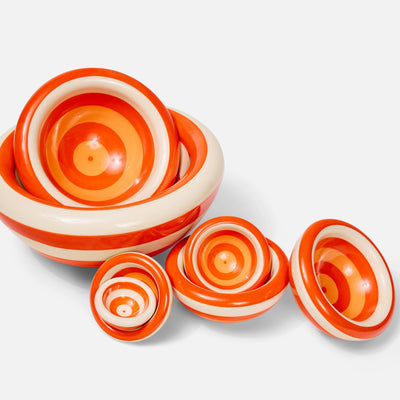 A set of ceramic bowls with concentric orange and cream spiral patterns, arranged on a white background.